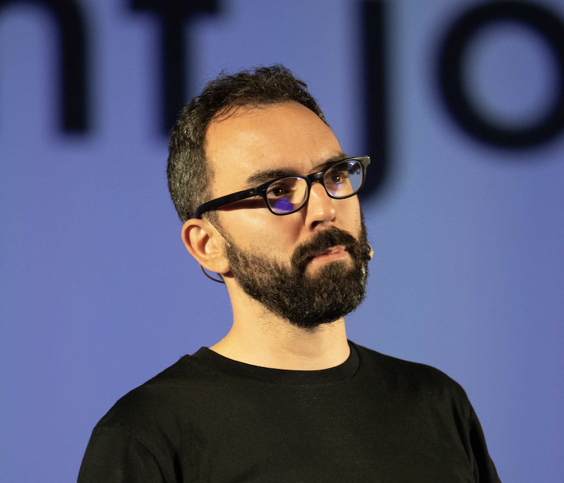 Bearded man wearing black glasses and black T-shirt